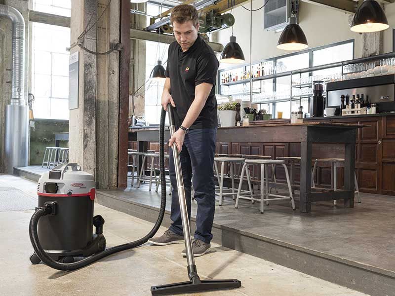 Ein Mann benutzt in einem Restaurant einen Staubsauger.