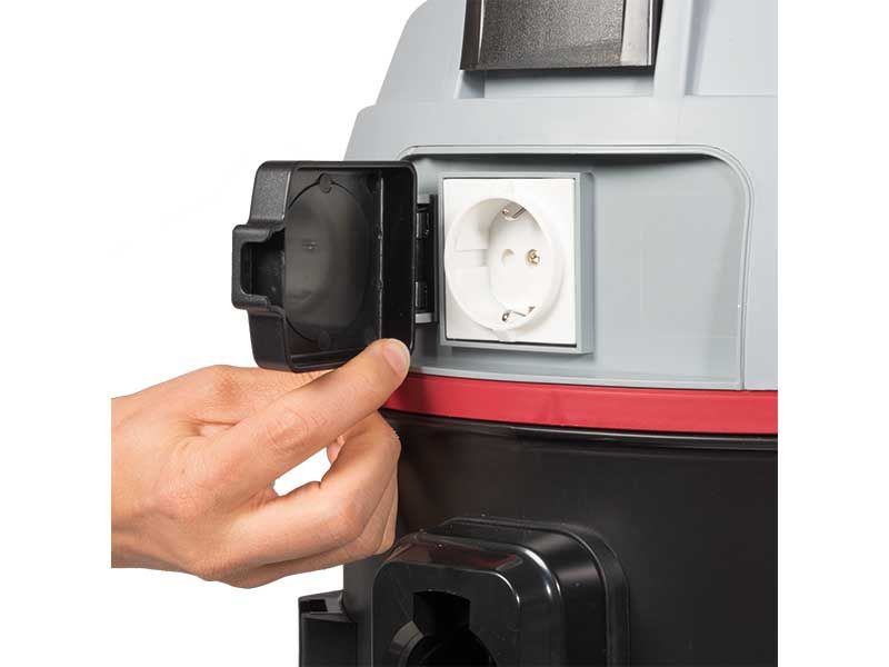 Eine Person steckt einen Staubsauger in die Steckdose.