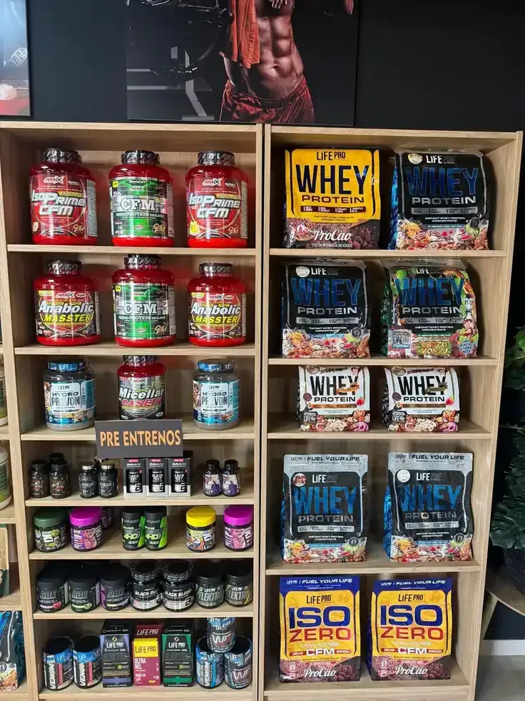 Persona con traje de protección rociando un sistema de pesticida montado en un vehículo sobre arbustos