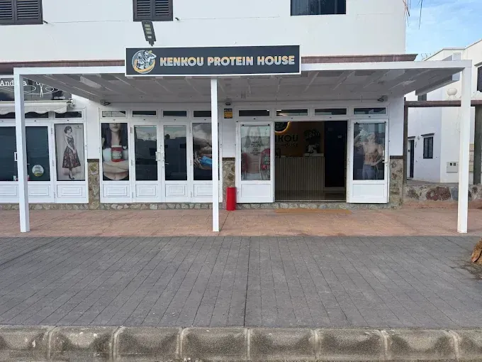 Tienda KENHOU PROTEIN HOUSE, fachada, toldo blanco, puertas de cristal, pasarela de hormigón.