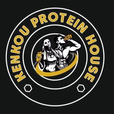 Logotipo de "Kenkou Protein House" que presenta a un hombre y una mujer bebiendo batidos de prote&iacute;nas en un arco dorado, enmarcados por un c&iacute;rculo blanco y dorado sobre negro.