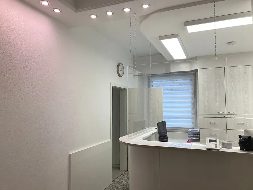 Ein Empfangsbereich in einem Krankenhaus mit einer Uhr an der Wand.