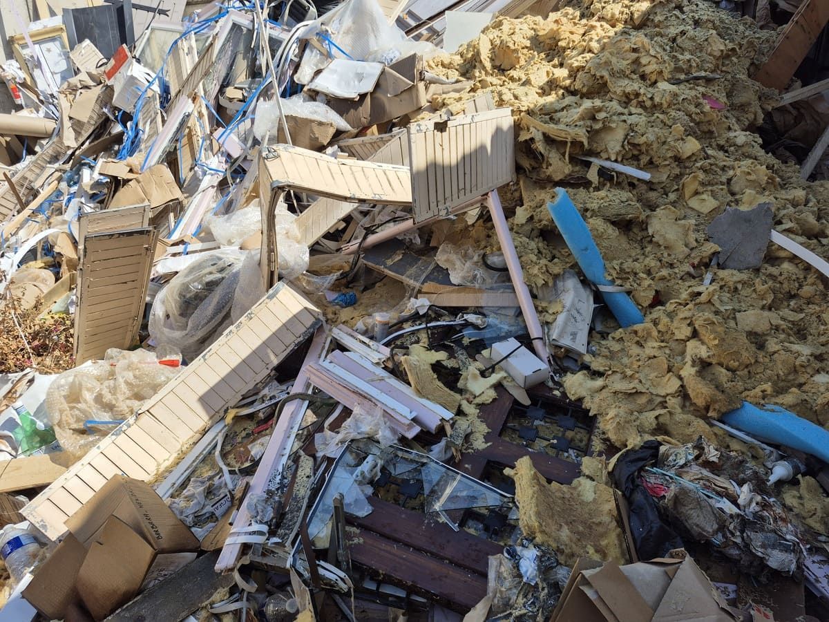 Tas de débris de construction comprenant du bois, du carton, de l'isolant et des tuyaux.