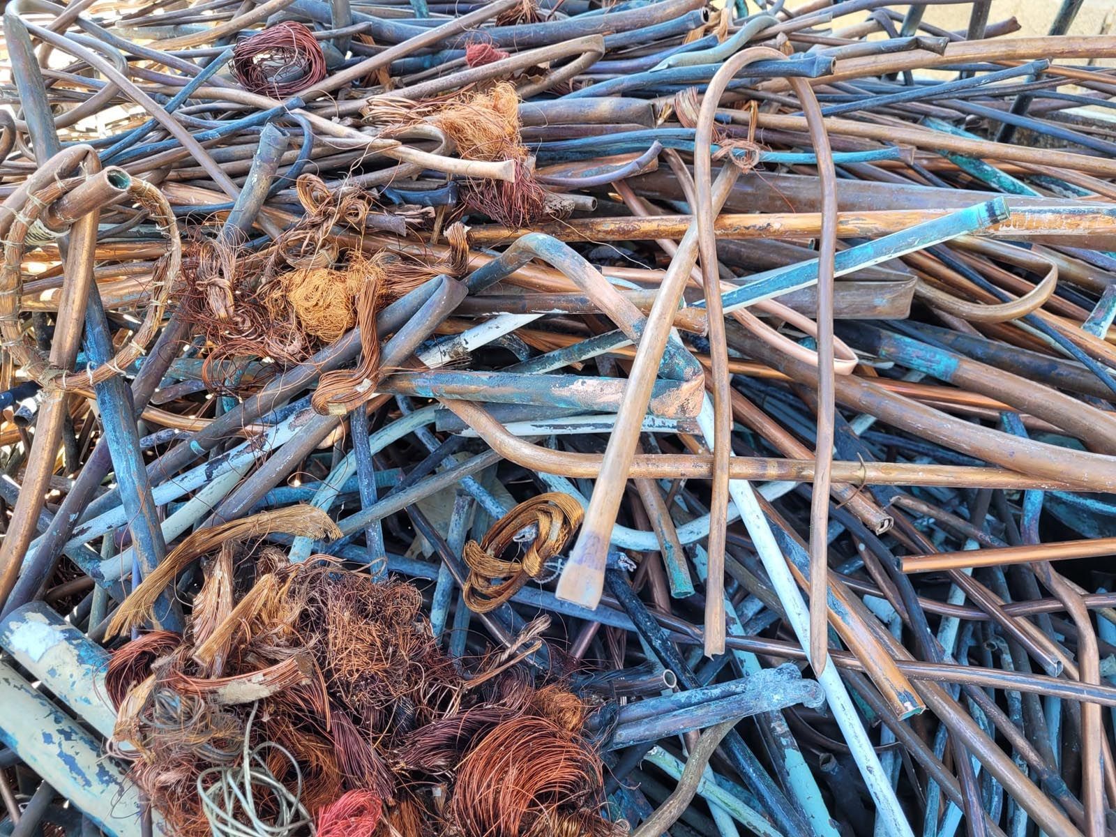 Tas de déchets métalliques et de fils mélangés, comprenant divers métaux.