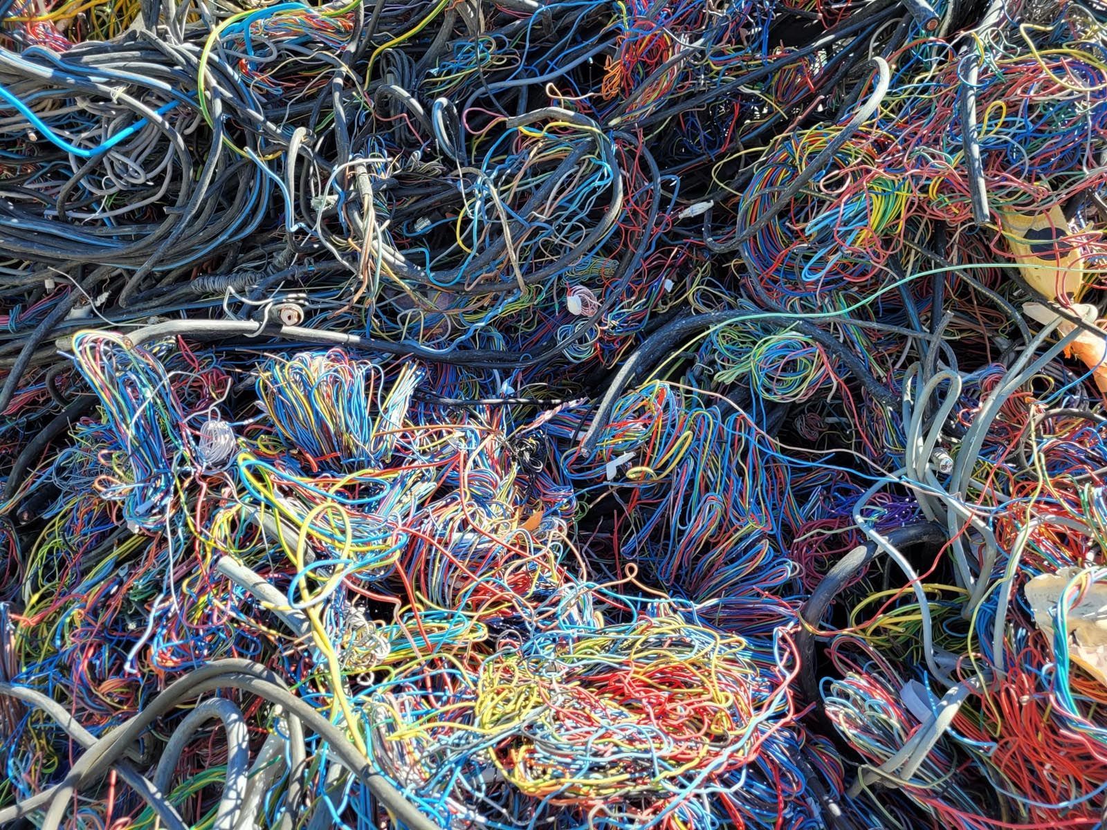 Un tas de fils électriques colorés et emmêlés, prêts à être recyclés.