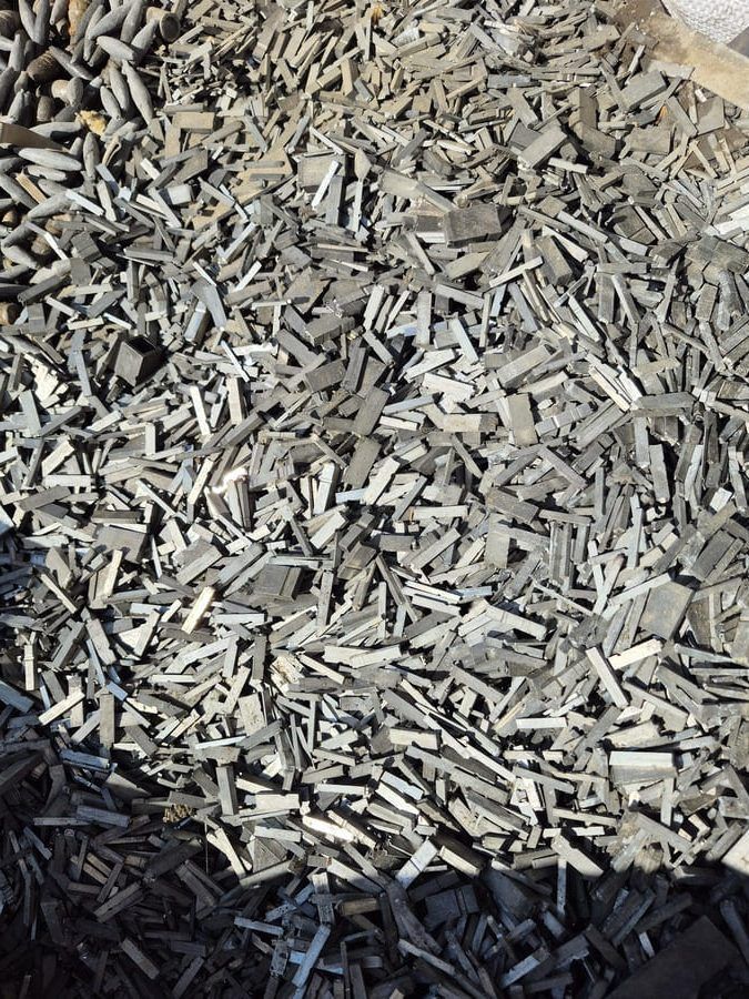 Tas de ferraille grise, de formes rectangulaires, à l'extérieur.