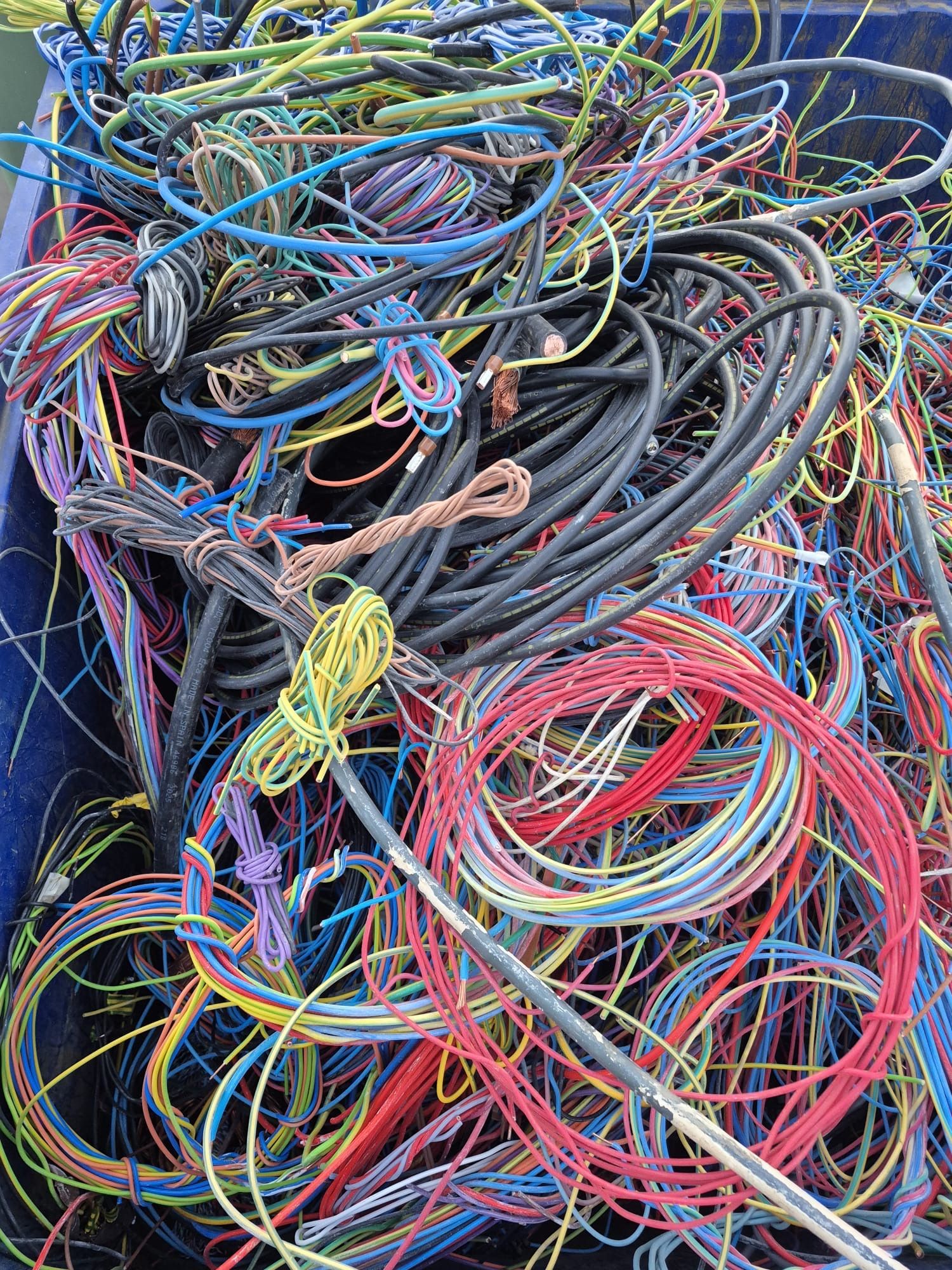Un tas de fils électriques colorés et emmêlés, prêts à être recyclés.