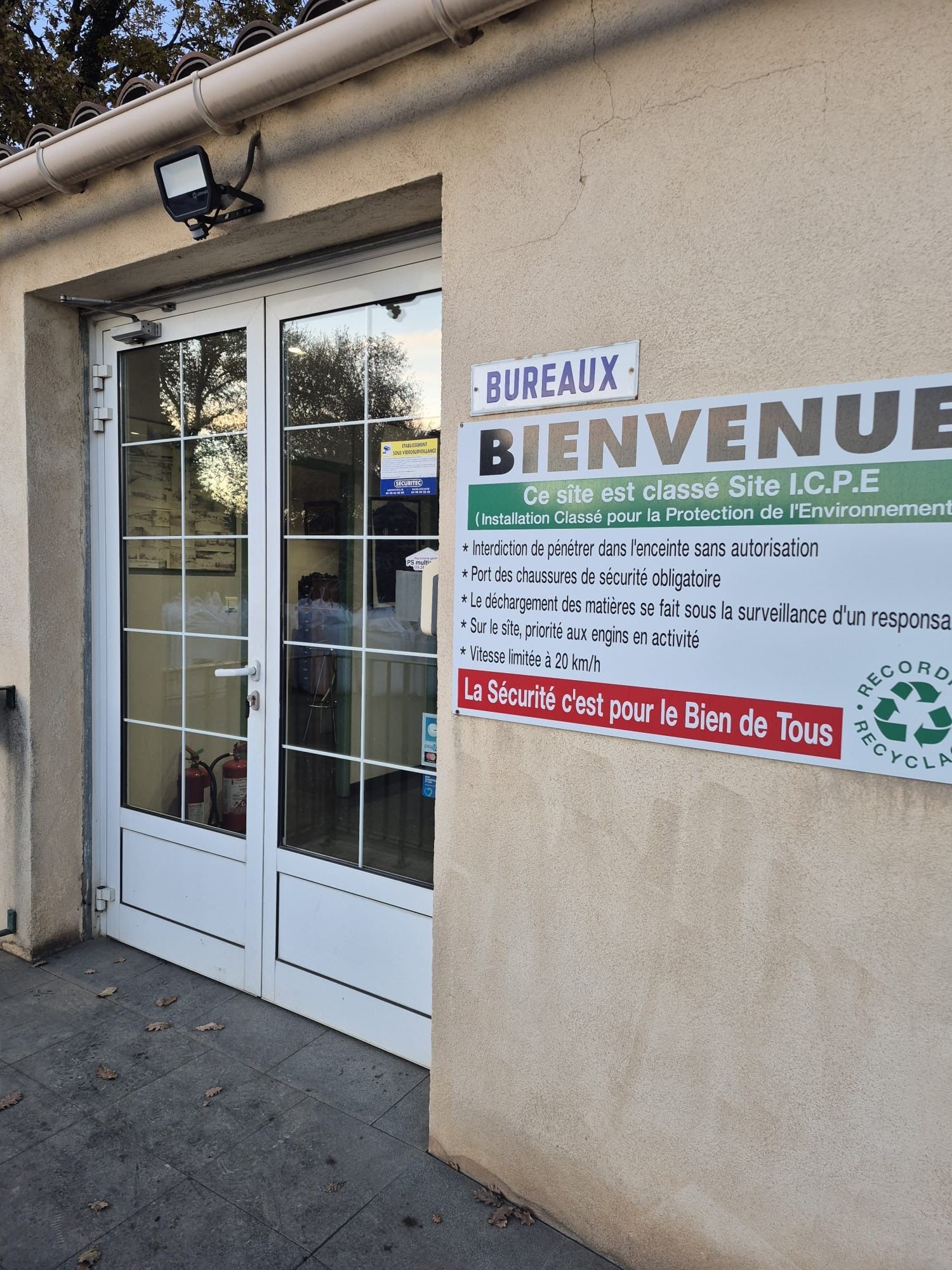 Entrée du bureau de l'entreprise Ets Recordier Recyclage avec panneau « Bienvenue », porte blanche et éclairage de sécurité.