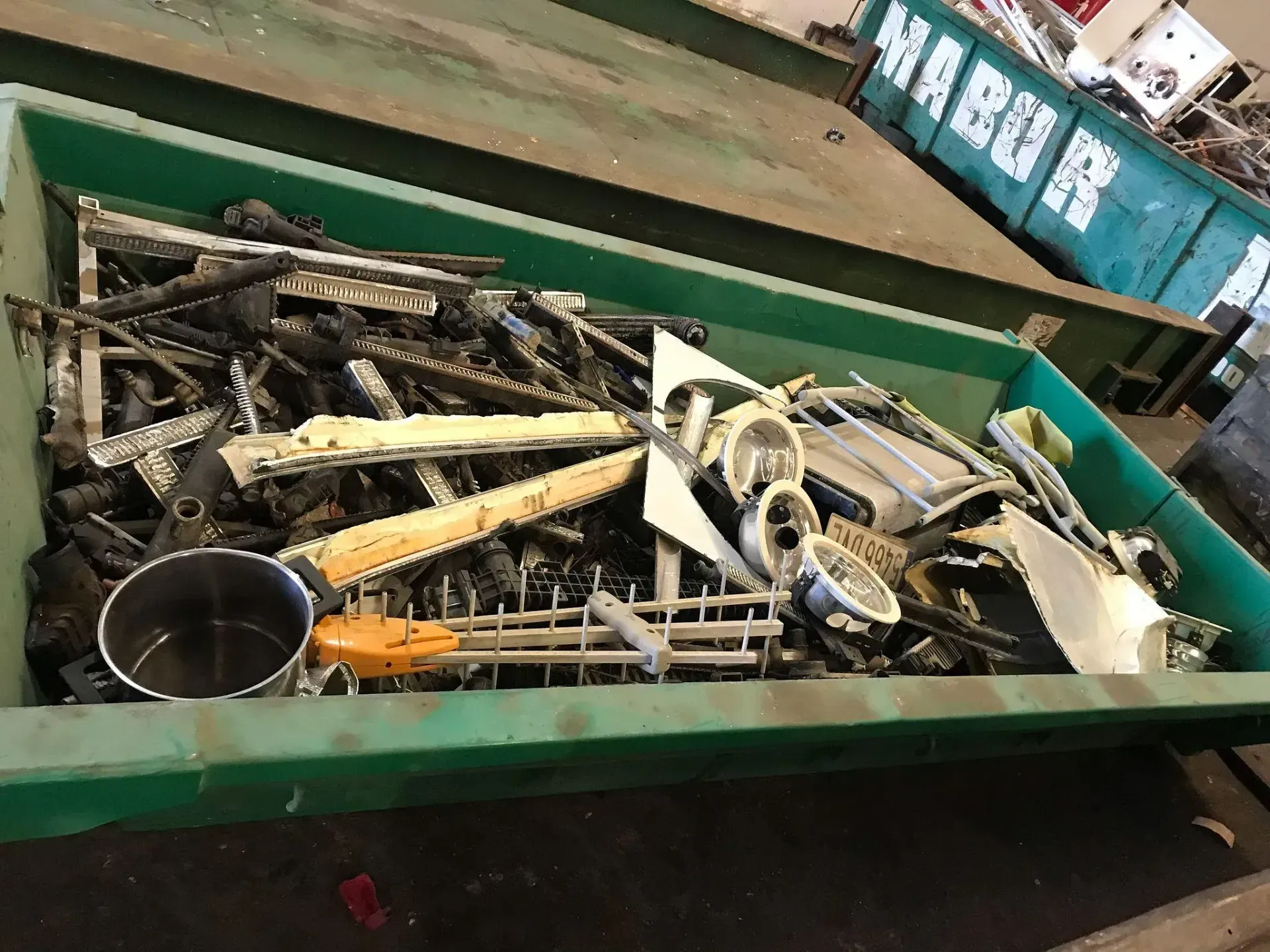 Un contenedor verde lleno de chatarra.