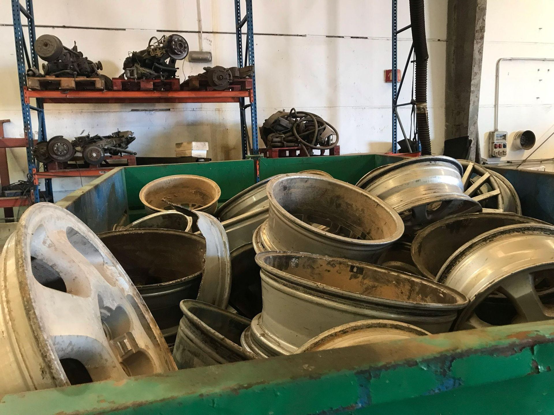 Un contenedor verde lleno de un montón de ruedas en un almacén.