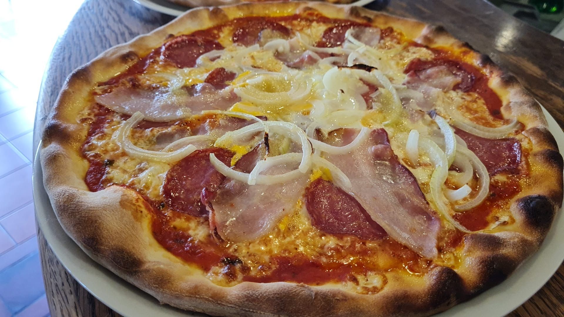 A group of people are sitting at a table eating pizza and drinking wine.