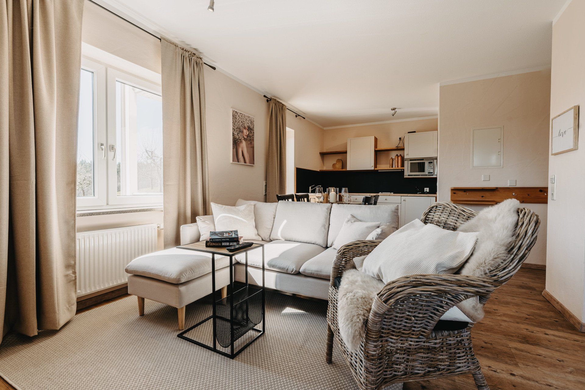 Ein Wohnzimmer mit Couch, Sessel, Ottomane und Tisch.