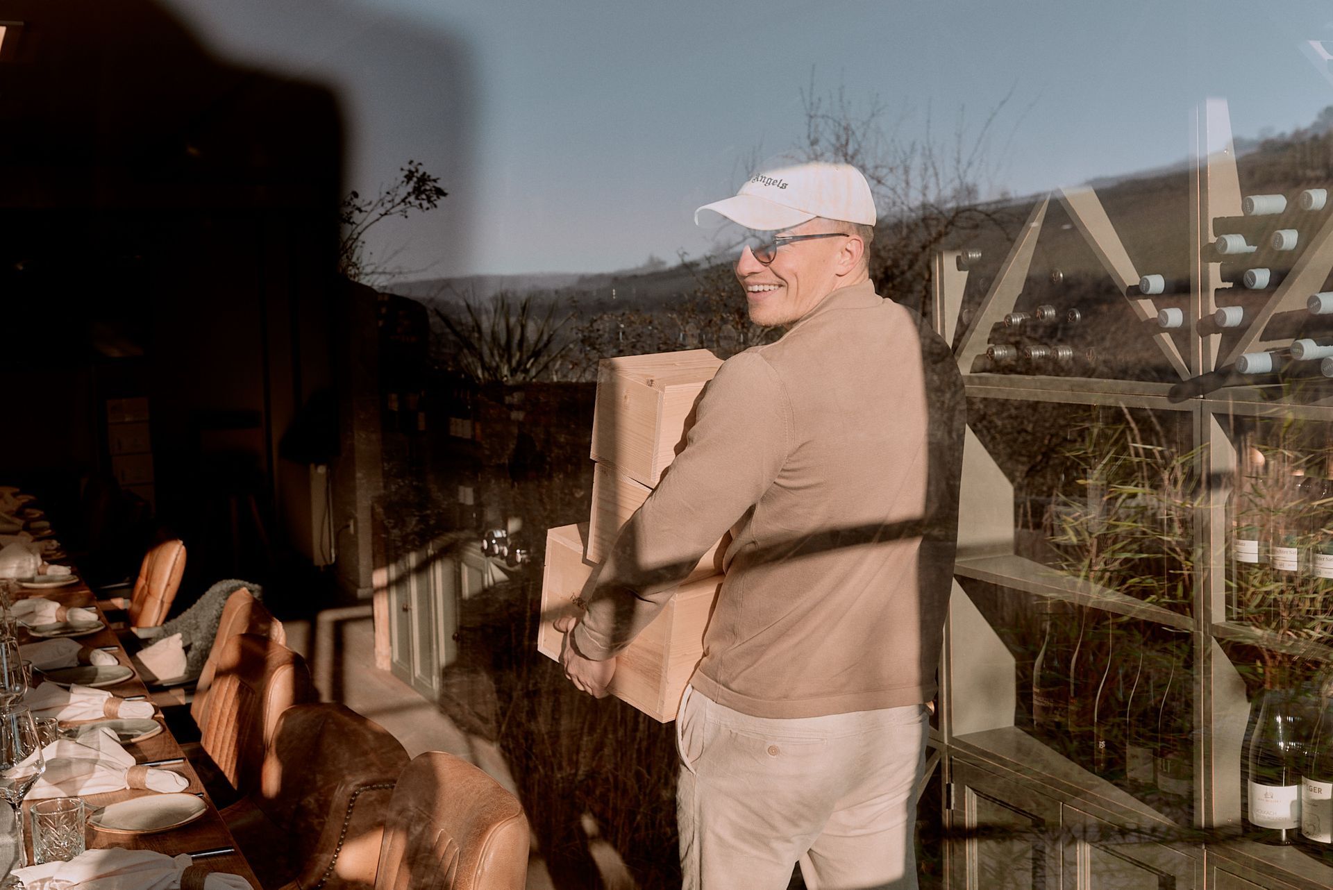 Ein Mann mit einem weißen Hut trägt eine Kiste.