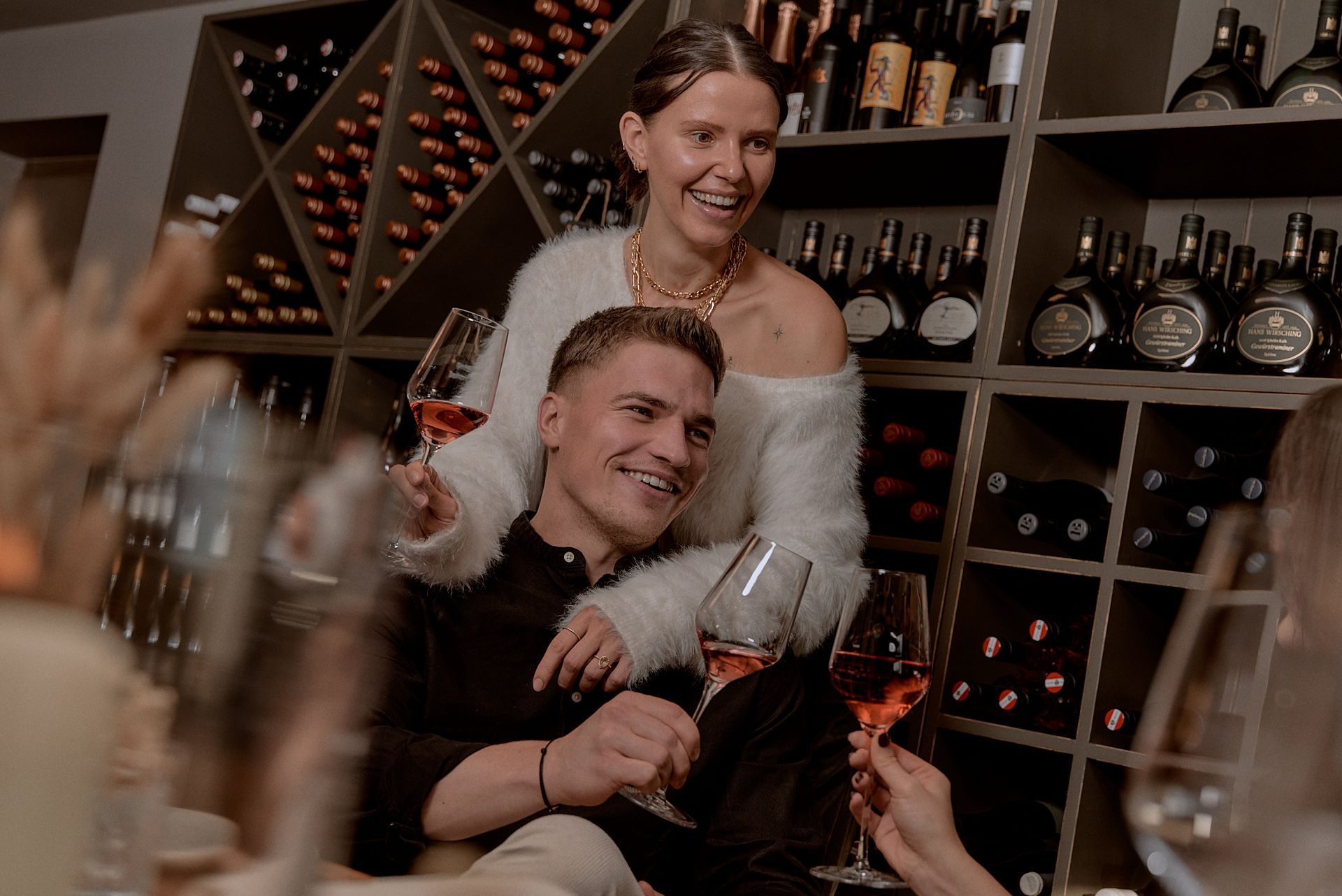 Ein Mann und eine Frau halten Weingläser in einem Weinkeller.