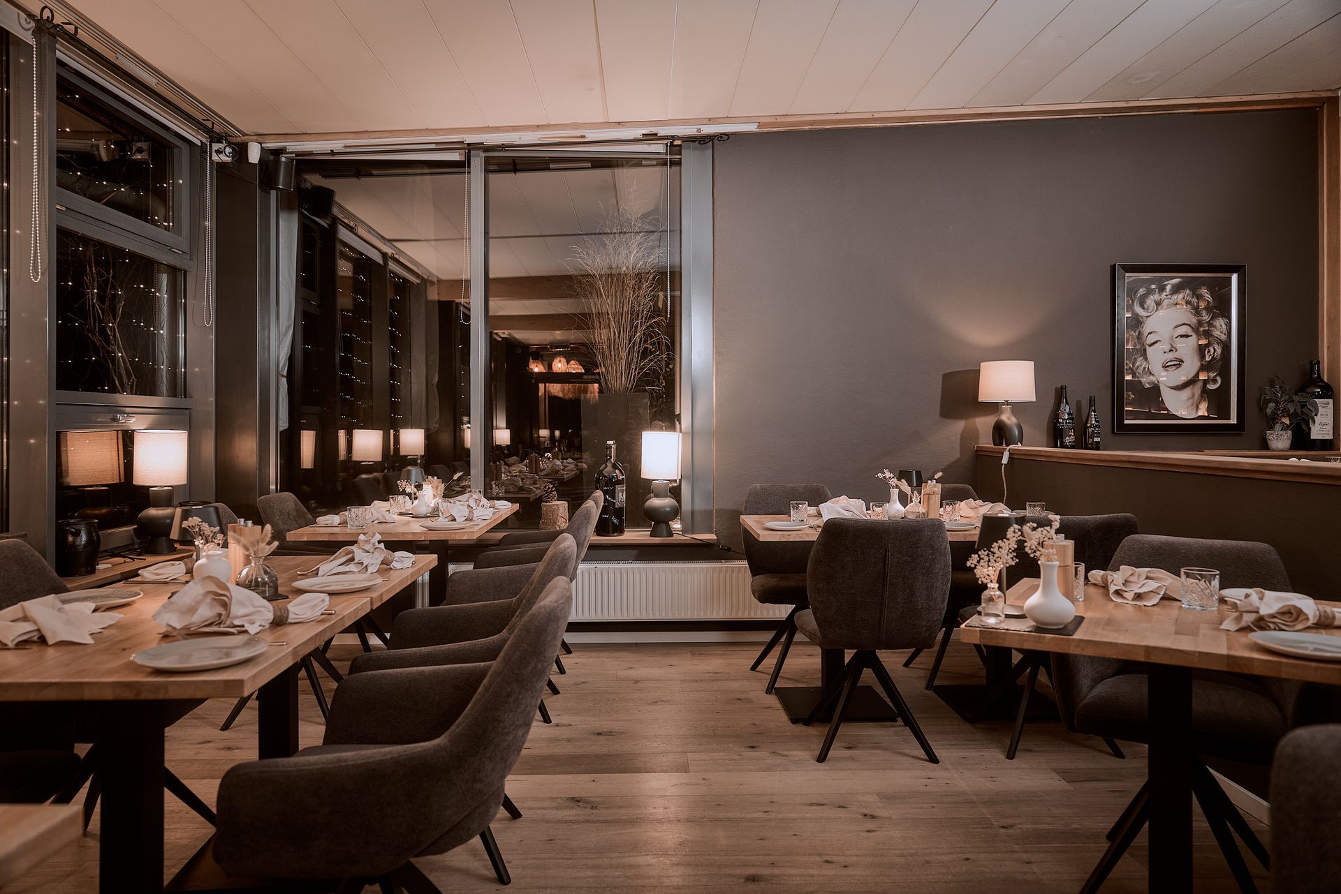 Ein Restaurant mit Tischen und Stühlen und einem Bild von Marilyn Monroe an der Wand.