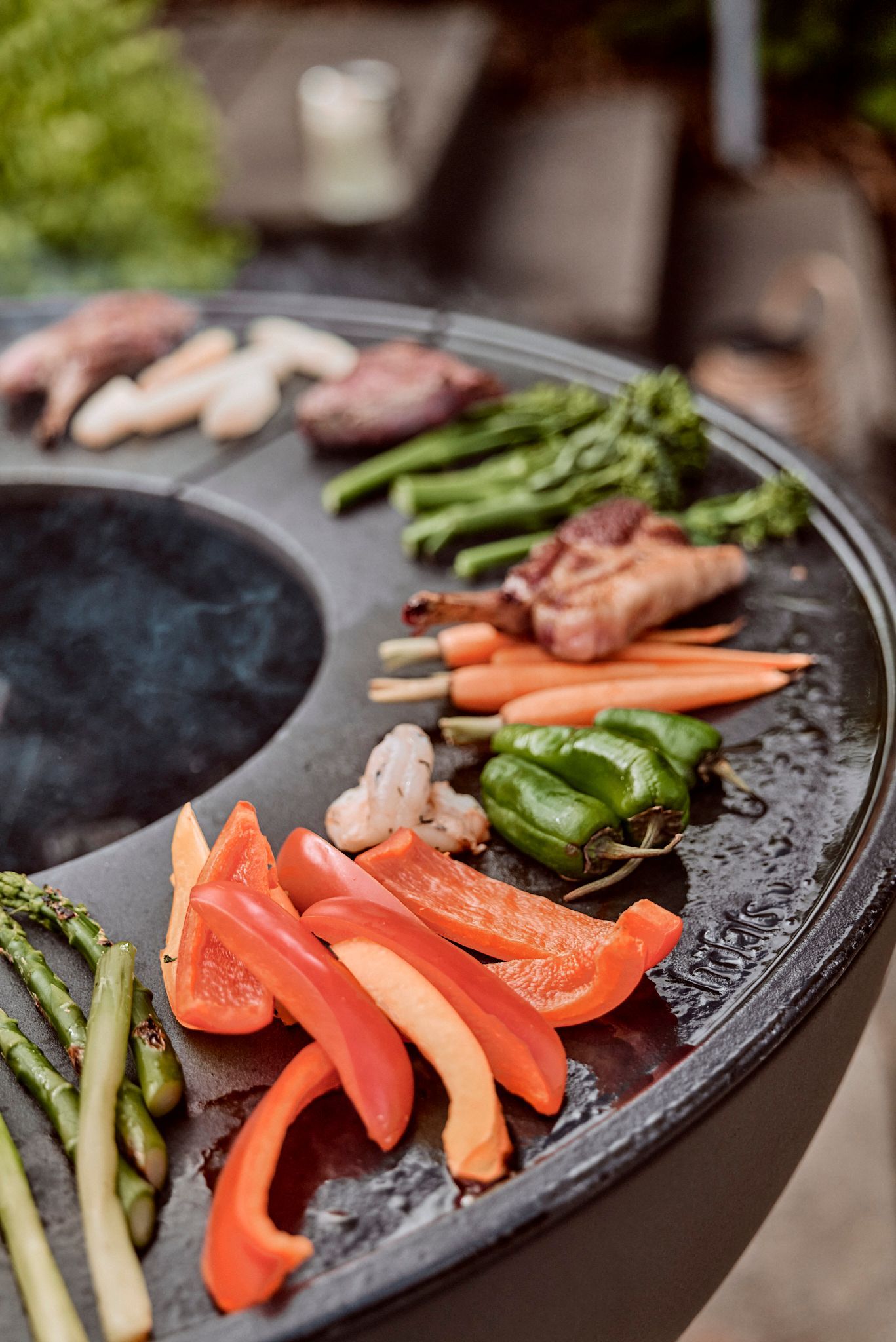 Ein Tisch mit Gemüse und Fleisch auf einem Grill.