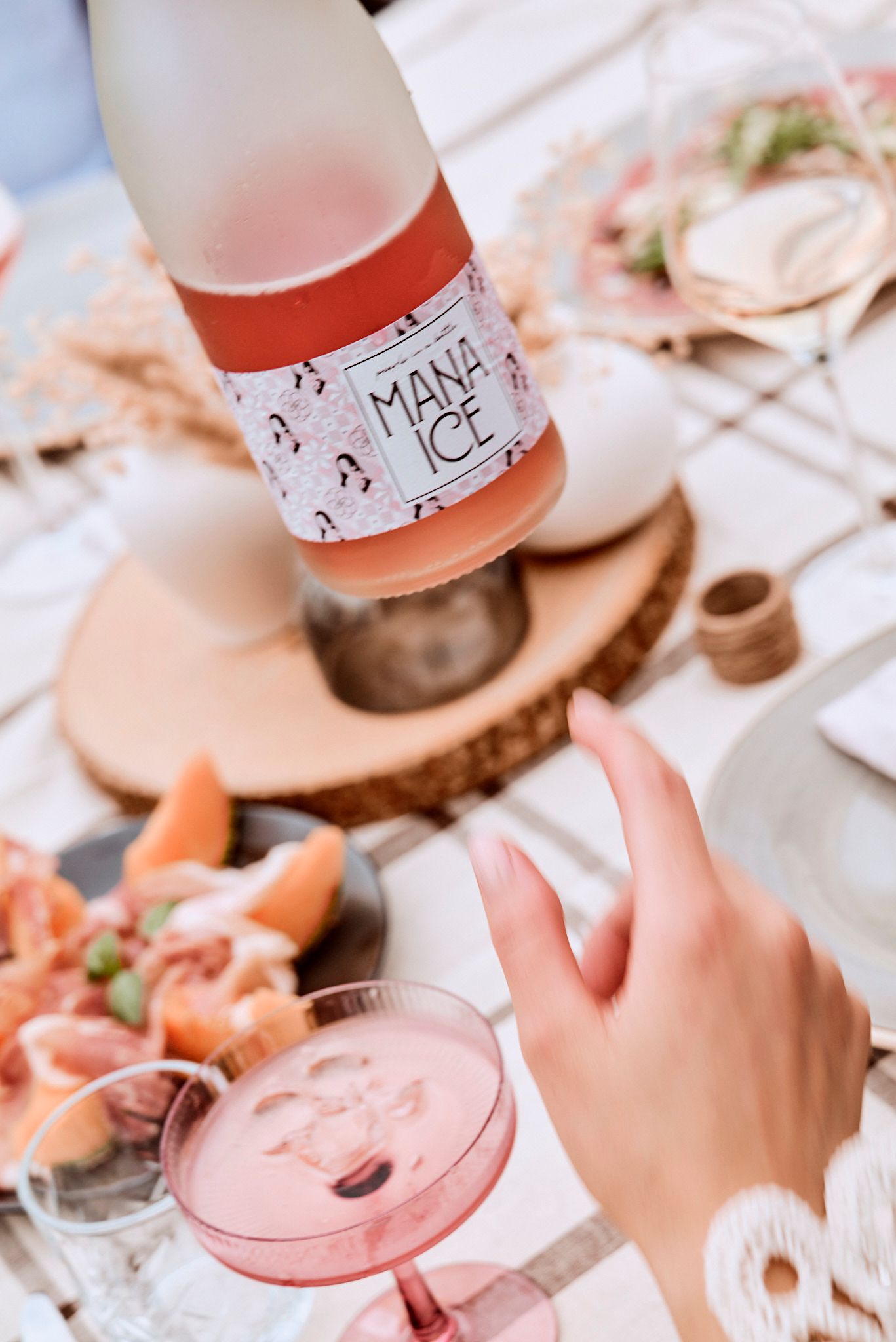 Auf einem Tisch wird eine Flasche Wein in ein Glas gegossen.