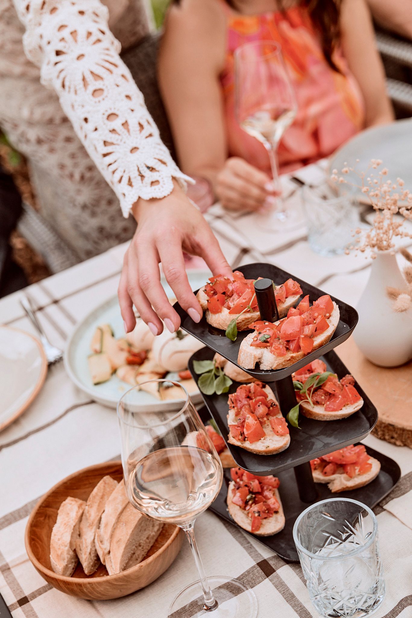 Eine Frau serviert einer Gruppe von Leuten an einem Tisch Essen.