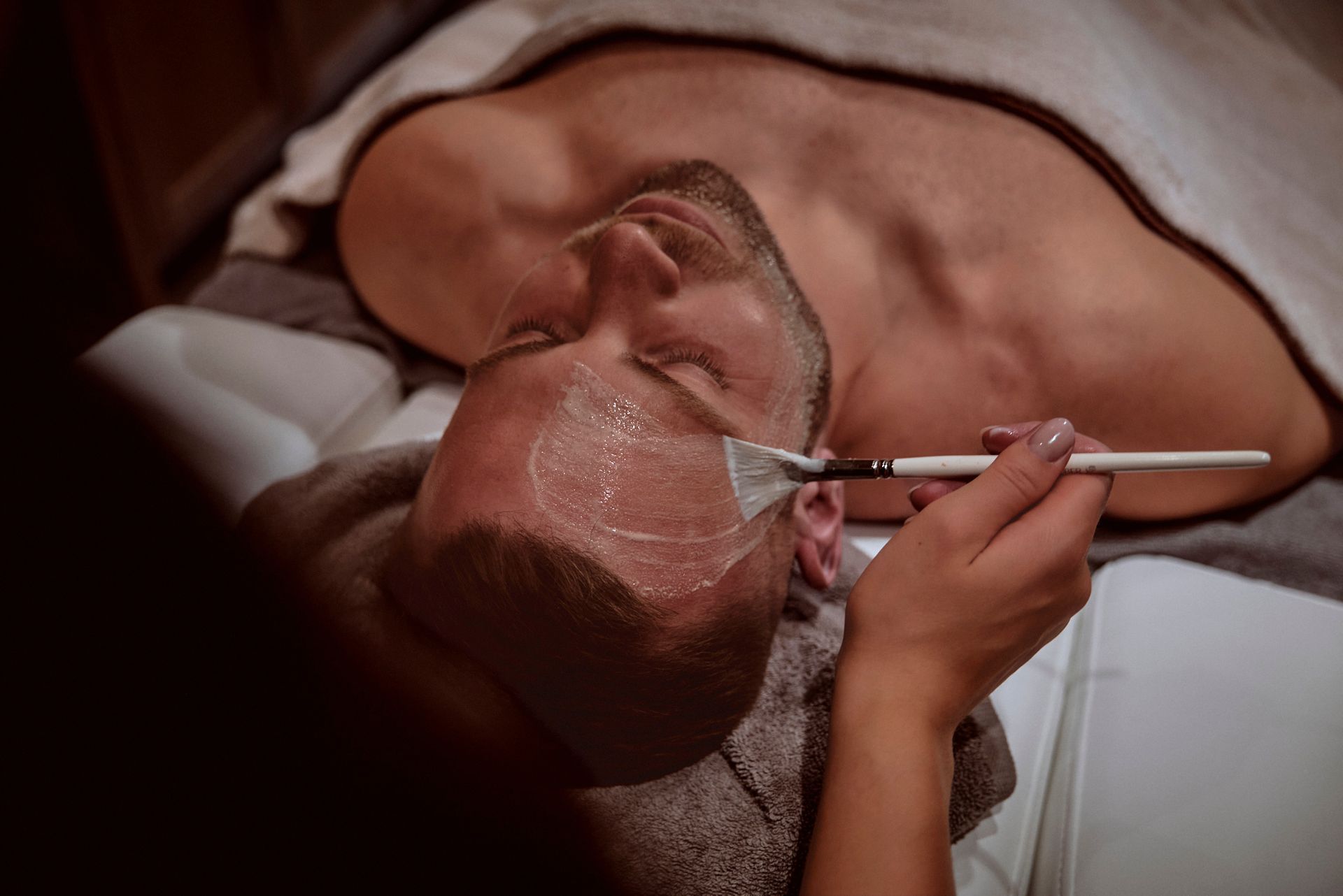 Ein Mann bekommt in einem Spa eine Gesichtsbehandlung.