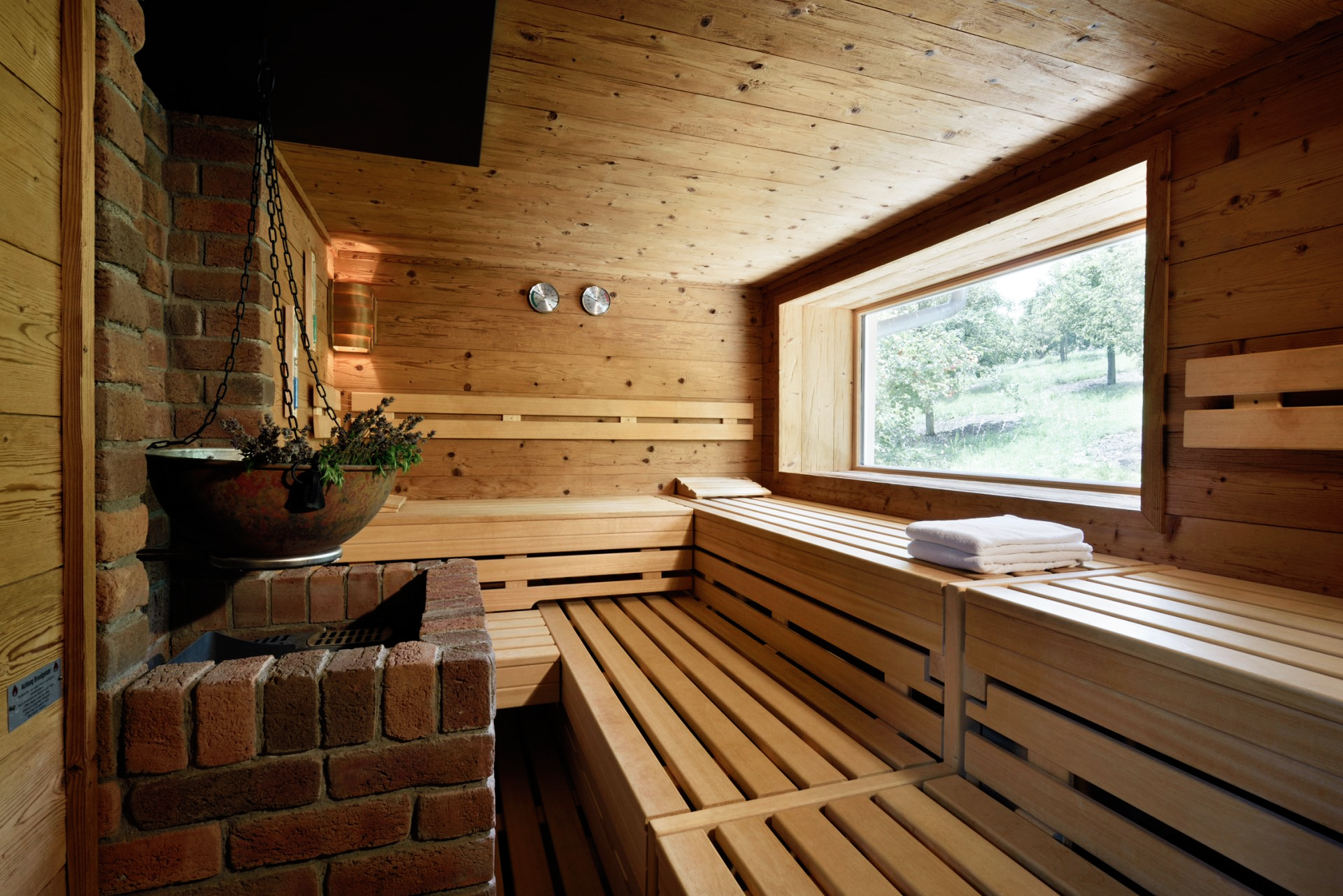 Eine Holzsauna mit großem Fenster und Holzbänken