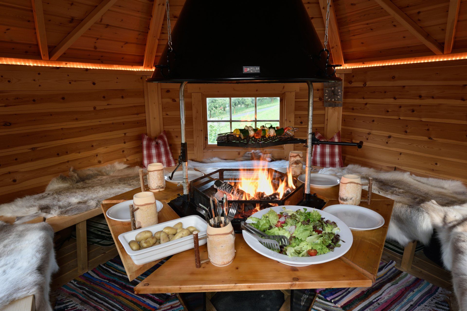 Ein Holztisch mit Tellern voller Essen und ein Kamin im Hintergrund.