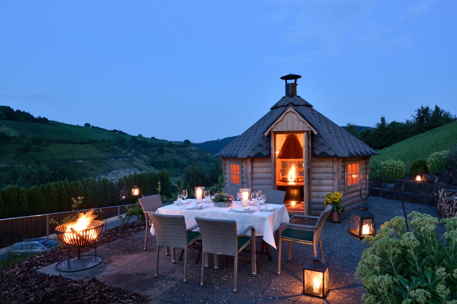 Eine kleine Hütte mit einem Tisch und Stühlen davor