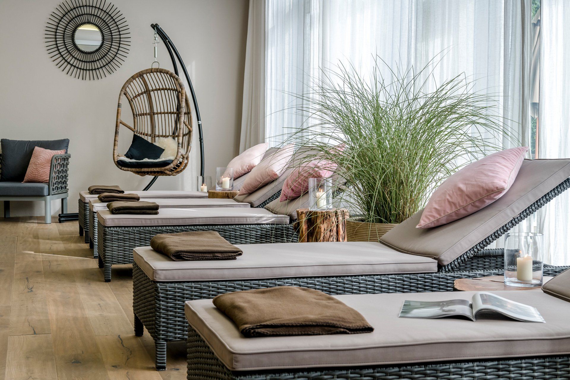 Ein Raum mit vielen Liegestühlen und einem Hängesessel.