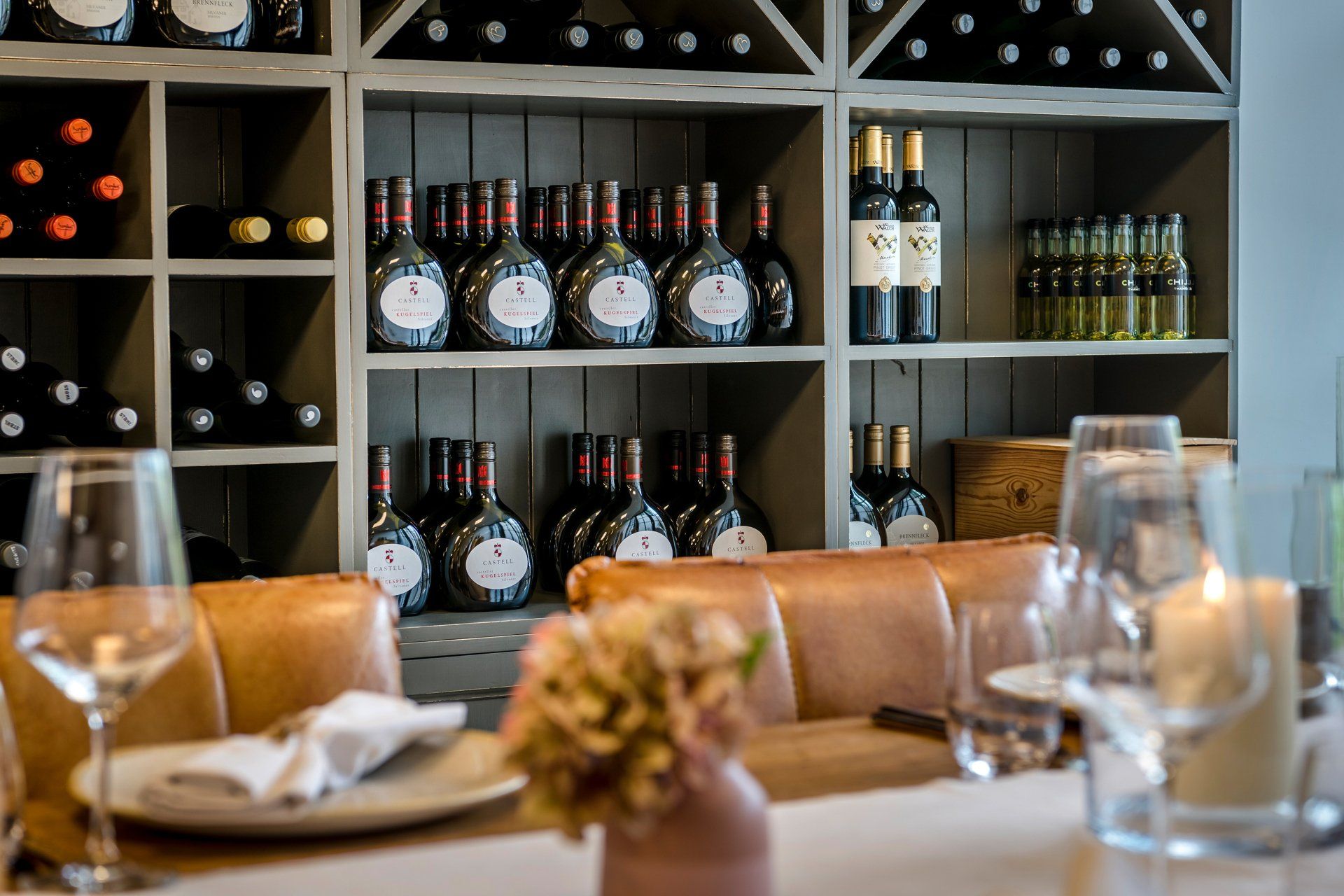 Im Hintergrund stehen viele Flaschen Wein auf den Regalen.