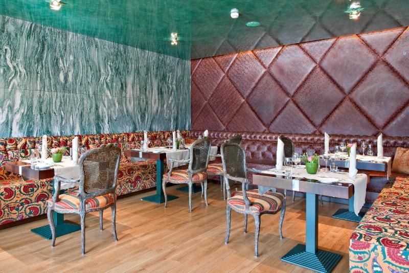 Un ristorante con tavoli e sedie e un soffitto verde.