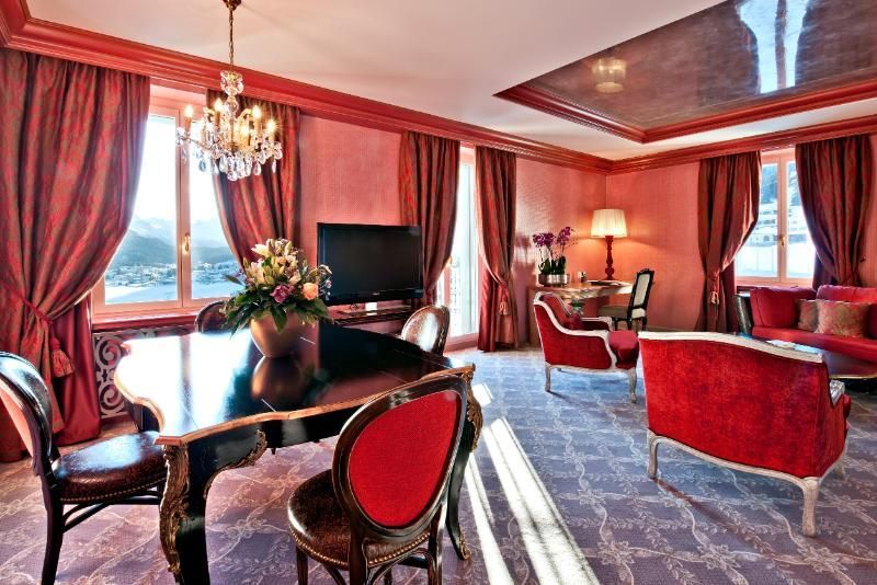 Un soggiorno con pianoforte, sedie, divano e televisione.