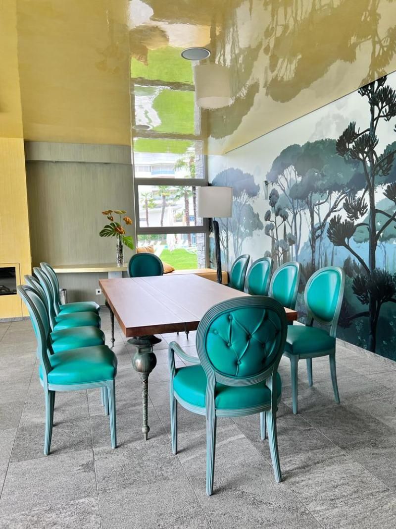 Una stanza con tavolo e sedie e un quadro sul muro.