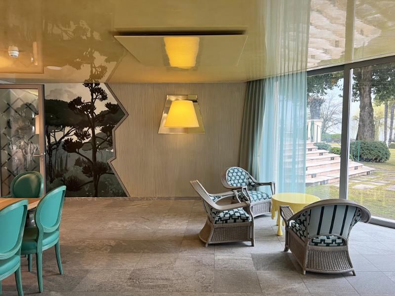 Una stanza con molte sedie e tavoli e una grande finestra.