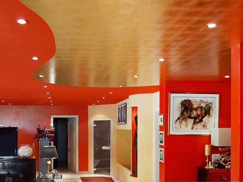 Un soggiorno con pareti rosse e soffitto dorato