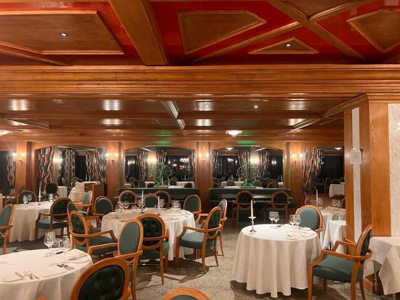 Una grande sala da pranzo piena di tavoli e sedie.