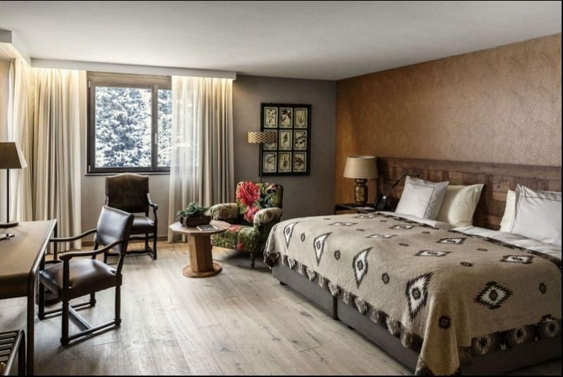 Una camera d'albergo con un grande letto e sedie