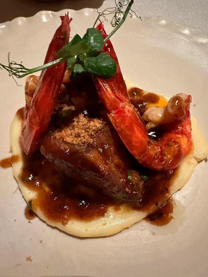 Un primer plano de un plato de comida con camarones y carne.