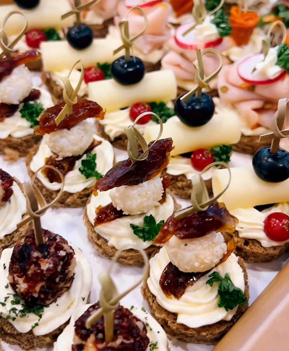 Un montón de aperitivos en palillos sobre una mesa.