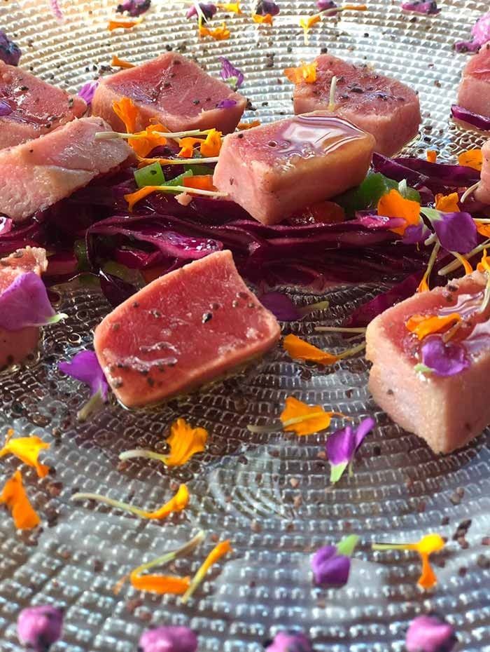 Un primer plano de un plato de comida con flores encima.
