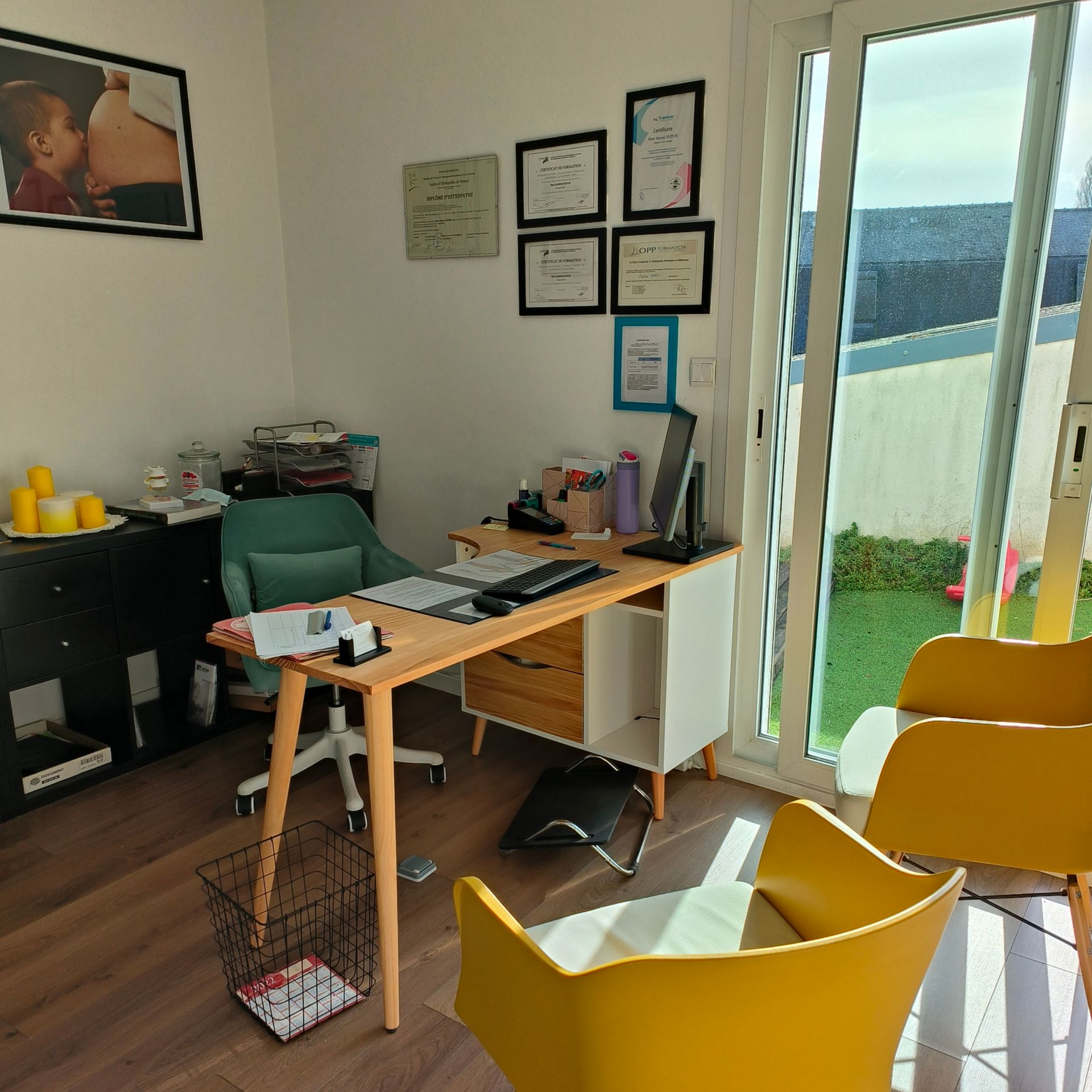 Bureau avec bureau, chaises et trophées accrochés au mur, près d'une porte vitrée donnant sur une cour.