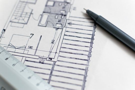 Un dibujo de una casa con una regla y un bolígrafo.