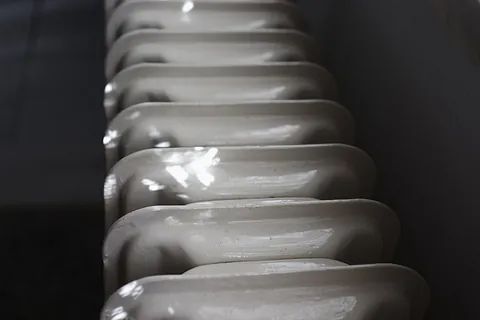 Una fila de radiadores blancos colocados uno al lado del otro en una pared.