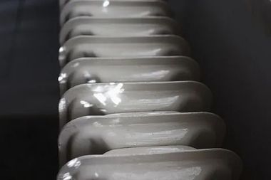 Una fila de radiadores blancos colocados uno al lado del otro en una pared.