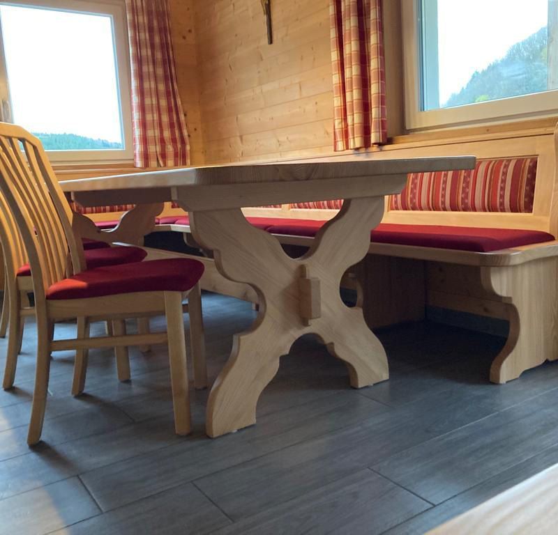 Ein großer Küchentisch mit einer Sitzecke und Stühlen