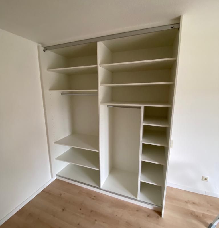 ein sehr großer weißer Kleiderschrank mit vielen Regalen