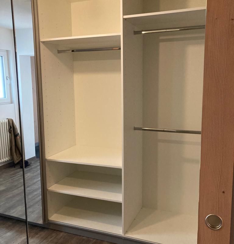 ein weißer Kleiderschrank mit Spiegeln und Regalen