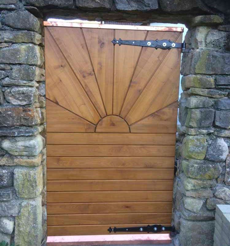 Ein hölzernes Gartentor mit einem Sonnenmuster