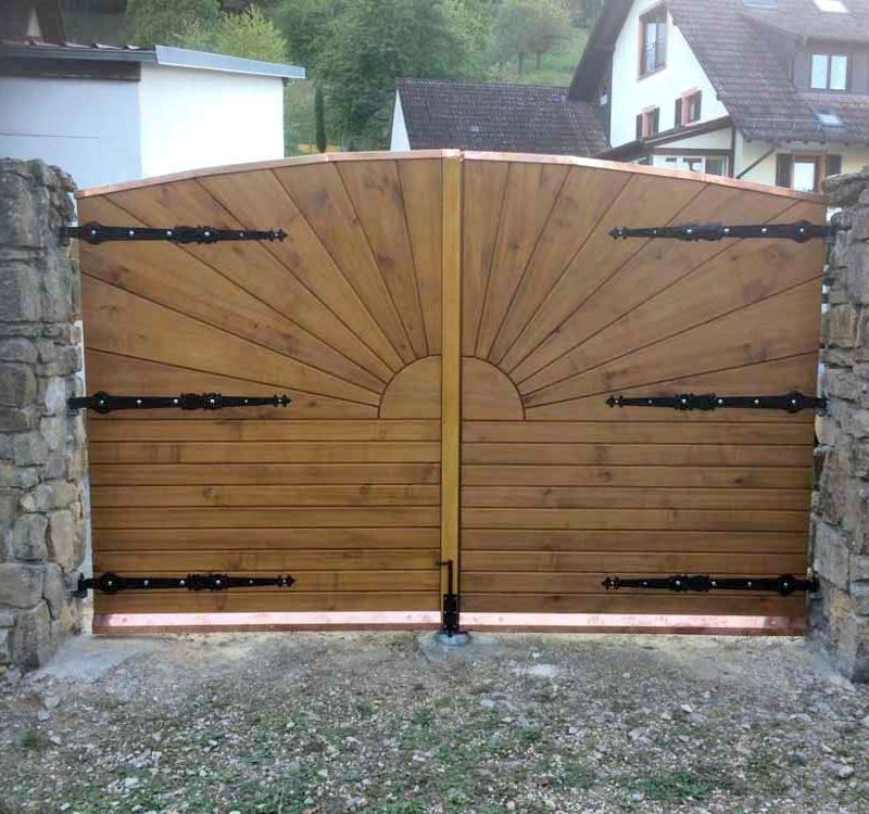 Ein hölzernes Tor mit einem Sonnenmuster
