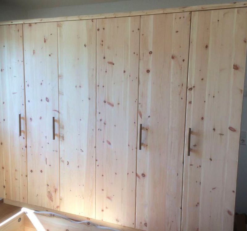 ein großer Holzschrank mit vielen Türen und Griffen