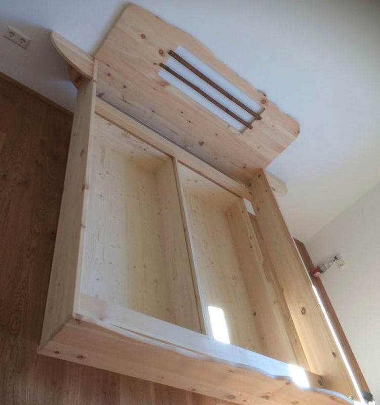 ein Schlafzimmer mit einem Holzbett mit großem Bettkasten