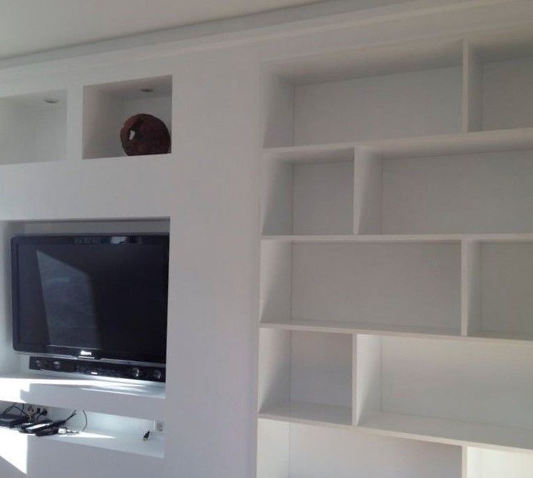 eine weiße TV Einbauwand mit vielen Fächern